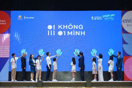 Các đại biểu và các em học sinh kích hoạt hưởng ứng chiến dịch "Không 1 mình". (Ảnh: KHẮC KIÊN)