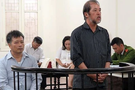 Hai bị cáo Nguyễn Đình Bang và Nguyễn Huy Khang tại một phiên sơ thẩm. (Ảnh: LÊ NHUNG)