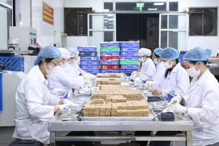 Gần 12 giờ đêm, người lao động Công ty Cổ phần 22 vẫn miệt mài sản xuất để kịp thời hoàn thành 30 tấn lương khô hỗ trợ bà con vùng lũ.