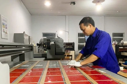 Nhân viên Phân xưởng Cơ khí-Cơ điện, Nhà máy Z157 tăng ca, tăng kíp sản xuất biển số xe bảo đảm kịp thời gian.