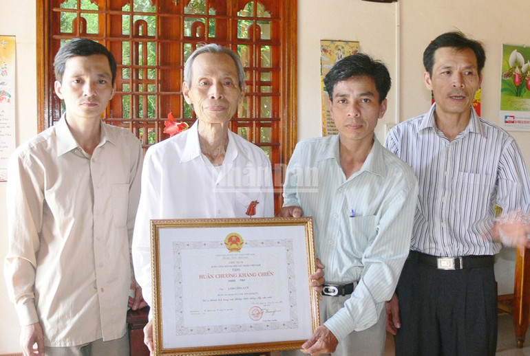 Bí thư Đảng ủy xã Gio An Hồ Xuân Hải trao Huân chương Kháng chiến hạng Nhất cho ông Lâm Công Lũy. ndo_c_gia-binh-3.jpg