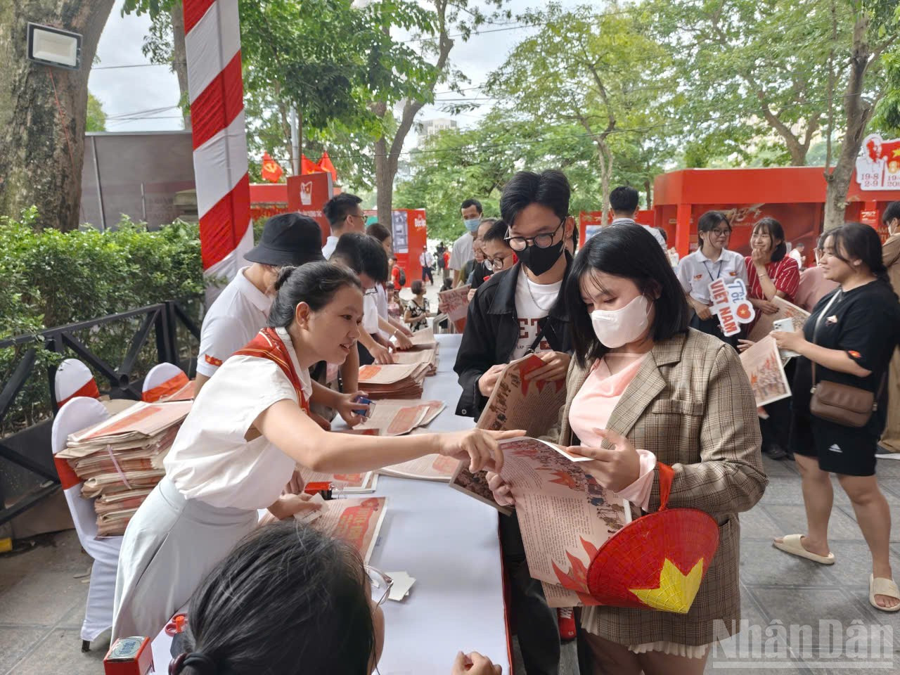 Hình ảnh người dân lắng nghe giới thiệu về ấn phẩm đặc biệt của Báo Nhân Dân. ndo_br_trienlam3.jpg