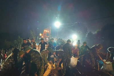 Lực lượng quân đội cùng người dân địa phương khẩn trương hộ đê, khắc phục sự cố.