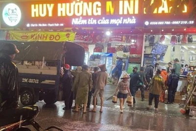 Lực lượng chức năng hỗ trợ người dân di dời ra khỏi khu vực sạt lở nguy hiểm. 