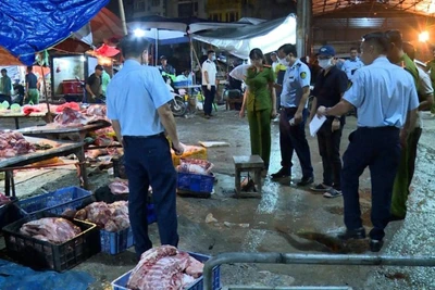 Lực lượng chức năng kiểm tra kiot kinh doanh thịt lợn "bẩn" tại khu vực chợ Phùng Khoang. (Ảnh: Công an thành phố Hà Nội)