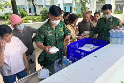 Cán bộ, chiến sĩ Đồn Biên phòng Xuân Đài phát những hộp cơm và chai nước uống 0 đồng cho người dân vùng thiên tai.