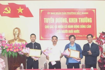Chủ tịch Ủy ban nhân dân phường Bắc Gianh Nguyễn Văn Tình trao giấy khen cho 3 cá nhân dũng cảm cứu người bị nạn.