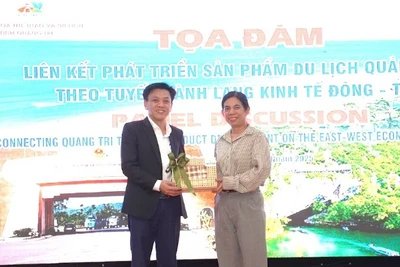 Đại diện lãnh đạo Sở Văn hóa, Thể thao và Du lịch Quảng Trị (bên trái) tặng quà cho đại biểu dự Tọa đàm.