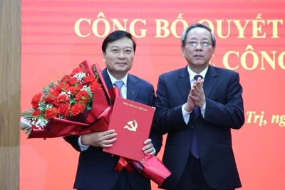 Đồng chí Hoàng Đăng Quang, Phó Trưởng Ban Thường trực Ban Tổ chức Trung ương trao quyết định và tặng hoa đồng chí Lê Hồng Vinh.