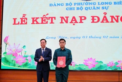 Bí thư Đảng ủy phường Long Biên trao quyết định kết nạp Đảng cho tân binh. (Ảnh: MINH PHÚC)