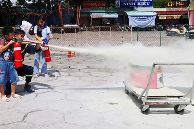 Các em thiếu nhi thực hành dùng bình chữa cháy dập lửa tại buổi tập huấn.