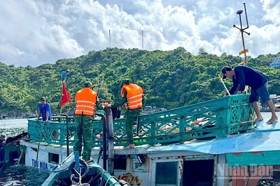 Cán bộ, chiến sĩ Đồn Biên phòng Hòn Chuối hỗ trợ trục vớt tàu cá gặp nạn bị chìm trên biển.