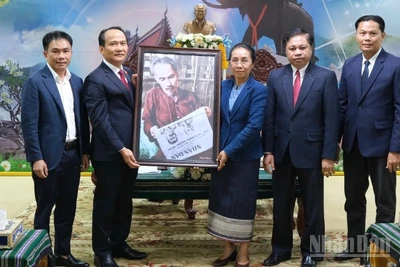 Phó Bí thư Thường trực Thành ủy Đà Nẵng Nguyễn Đình Vĩnh và đồng chí Phan Thái Sơn, quyền Trưởng đại diện Báo Nhân Dân tại miền trung-Tây Nguyên trao tặng bức ảnh Bác Hồ đọc Báo Nhân Dân cho lãnh đạo tỉnh Attapue-Lào. (Ảnh: ANH ĐÀO)