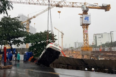 Vụ sụt lún cuốn theo hai chiếc xe ô-tô đang đậu trên vỉa hè rơi xuống hố sâu.