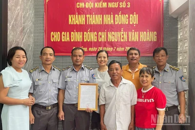 Đồng chí Vũ Văn Tài, Bí thư Đảng ủy Chi đội Kiểm ngư số 3 (thứ hai từ trái sang) trao kinh phí hỗ trợ nhà đồng đội cho gia đình đồng chí Nguyễn Văn Hoàng. (Ảnh: TIẾN DŨNG)