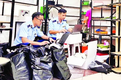 Lực lượng quản lý thị trường kiểm tra hàng hóa có dấu hiệu giả mạo tại điểm mua sắm Saigon Square (Quận 1) cuối tháng 5 vừa qua. (Ảnh CTV)