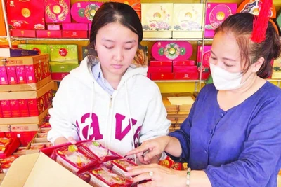 Mẹ con chị Bạch Thị Bích Phượng, chủ một cơ sở bán bánh trung thu trên đường Lê Thánh Tông, phường Buôn Ma Thuột chuẩn bị bánh bán cho khách hàng.