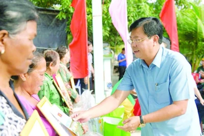 Bí thư Tỉnh ủy An Giang Nguyễn Tiến Hải trao quà tặng người dân tại lễ bàn giao nhà đại đoàn kết trong chương trình “Xóa nhà tạm, nhà dột nát”. (Ảnh QUỐC TRINH)