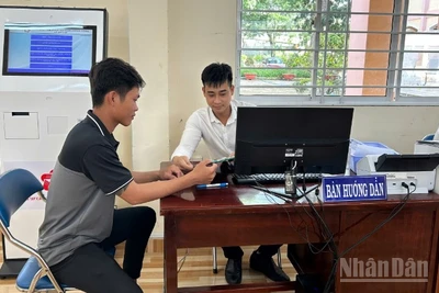 Cán bộ Trung tâm Phục vụ hành chính công xã Mỹ Lợi hướng dẫn người dân thao tác nộp hồ sơ trực tuyến. 