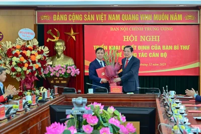 Đồng chí Phan Đình Trạc, Ủy viên Bộ Chính trị, Bí thư Trung ương Đảng, Trưởng Ban Nội chính Trung ương trao Quyết định và tặng hoa chúc mừng đồng chí Nguyễn Xuân Trường. (Ảnh: BẢO LONG)