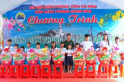 Đại tá Phạm Minh Giang, Chính ủy Bộ đội Biên phòng Cà Mau (đứng giữa) trao quà tặng học sinh nghèo vùng ven biển Gành Hào.