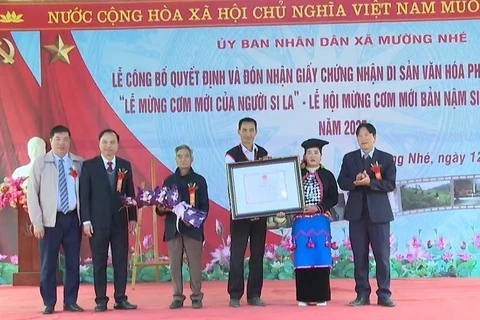 Các đồng chí lãnh đạo xã Mường Nhé trao Chứng nhận di sản văn hóa phi vật thể quốc gia cho đồng bào dân tộc Si La ở bản Nậm Sin với nghi lễ được công nhận là Lễ mừng cơm mới. 