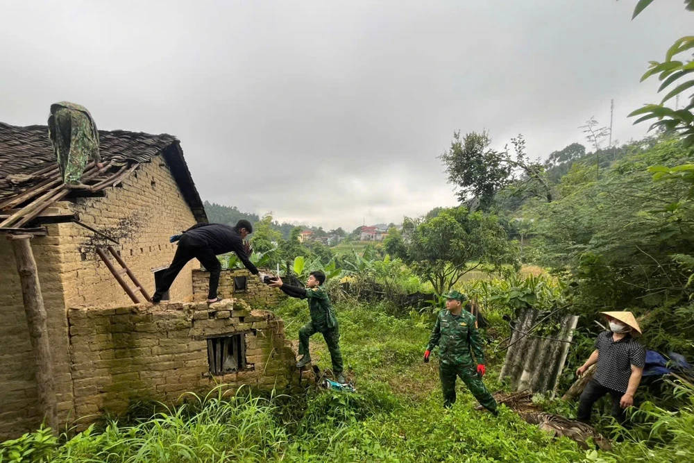 Cán bộ chiến sĩ biên phòng giúp đỡ xây sửa nhà cho người dân.