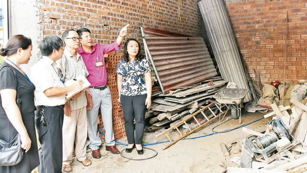 Cán bộ Phòng Lao động - Thương binh và Xã hội quận Ðống Ða kiểm tra công trình xây dựng nhà cho người có công tại phường Cát Linh. Ảnh: Ðăng Anh