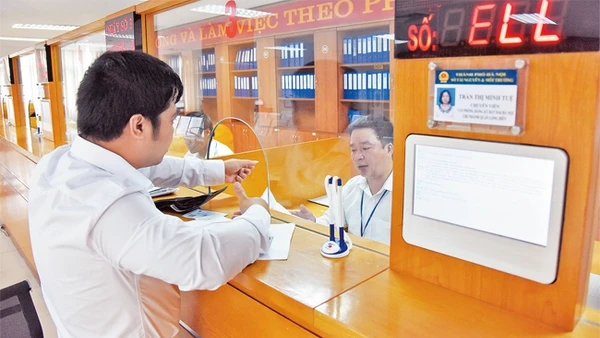Giải quyết thủ tục hành chính cho người dân tại Bộ phận một cửa UBND quận Long Biên. Ảnh: MINH HÀ