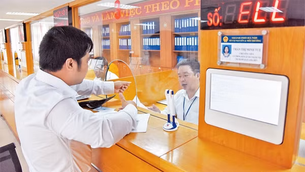 Giải quyết thủ tục hành chính cho người dân tại Bộ phận một cửa UBND quận Long Biên. Ảnh: MINH HÀ