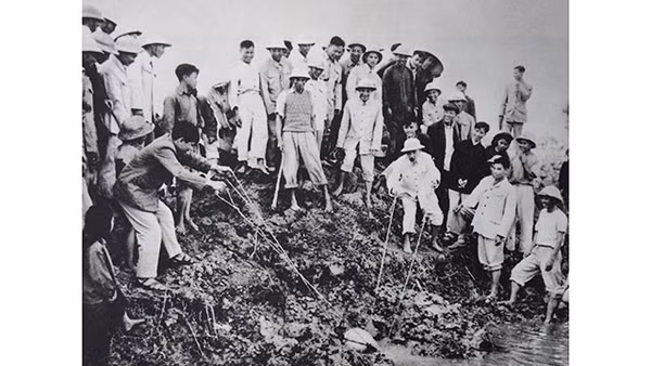 Chủ tịch Hồ Chí Minh tát nước chống hạn với bà con nông dân ở cánh đồng Quai Chải, xã Đại Thanh, huyện Thường Tín, Hà Đông (ngày 12-1-1958). Ảnh tư liệu