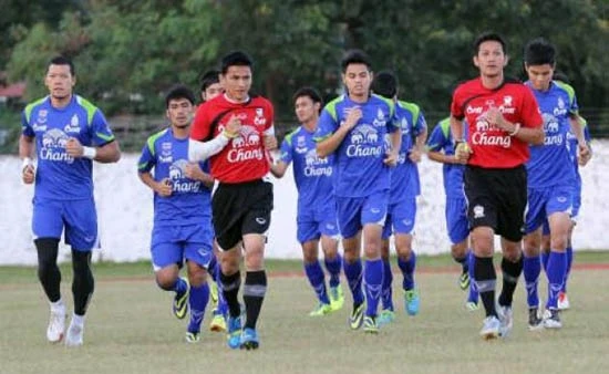 HLV Kiatisak (áo đỏ, trái) cùng các cầu thủ Thái-lan tập luyện trước trận bán kết gặp U23 Singapore.