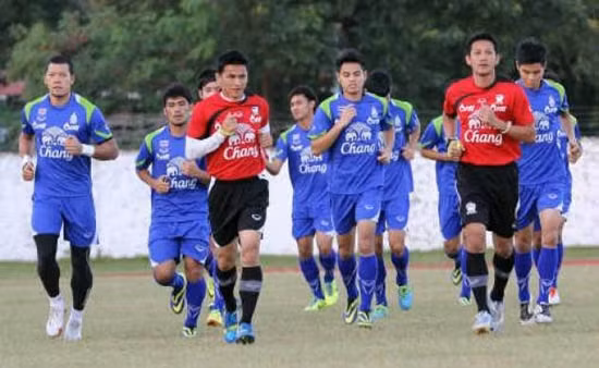 HLV Kiatisak (áo đỏ, trái) cùng các cầu thủ Thái-lan tập luyện trước trận bán kết gặp U23 Singapore.
