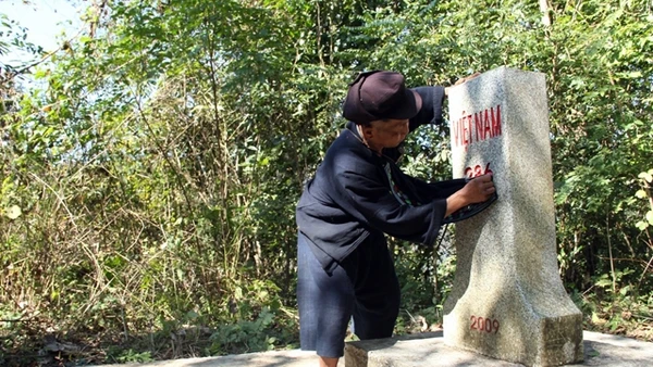 Già Xiết cẩn thận lau chùi cột mốc