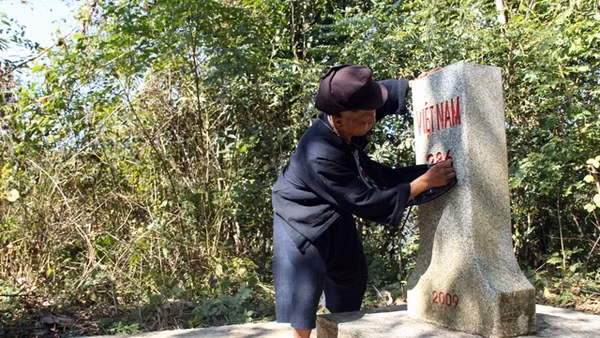 Già Xiết cẩn thận lau chùi cột mốc