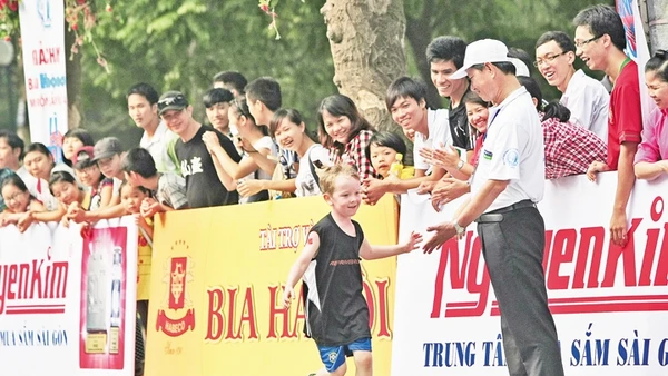 Em bé nước ngoài được chào đón và cổ vũ khi tham gia một sự kiện thể thao quốc tế tại Hà Nội. Ảnh: Minh Lê