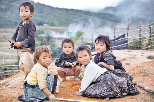 Mấy đứa trẻ đầu tóc bù xù, ngó nghiêng xem khách. 