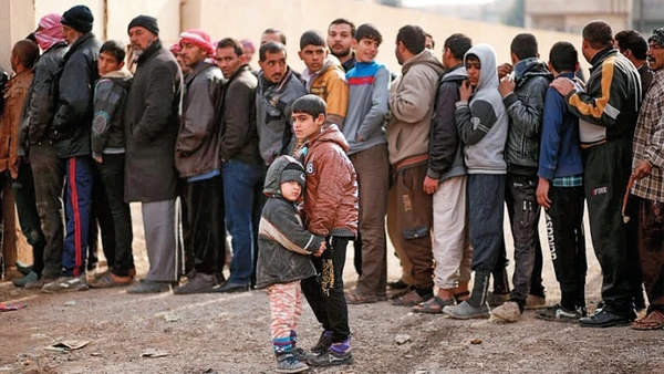 Hai đứa trẻ bên dòng người dân I-rắc chờ nhận viện trợ của Liên hợp quốc.