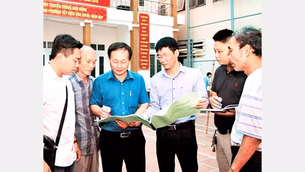 Cán bộ MTTQ phường Yết Kiêu, quận Hà Đông (Hà Nội) trao đổi, giám sát công việc cải tạo một công trình văn hóa. Ảnh: BÁ HOẠT