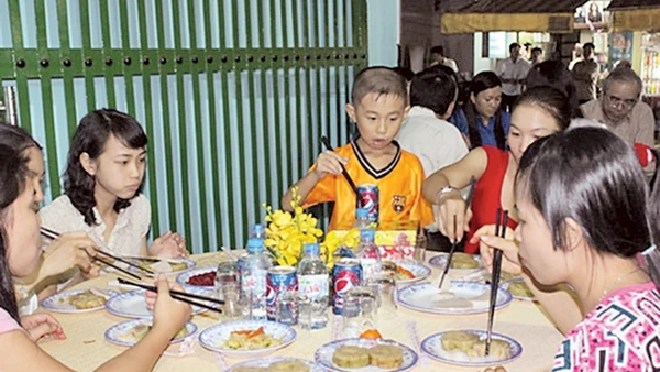 Các gia đình công nhân ăn Tết tại xóm trọ 143 Trần Thanh Mai, Q. Bình Tân, TP Hồ Chí Minh. Ảnh: TRUNG CHÁNH