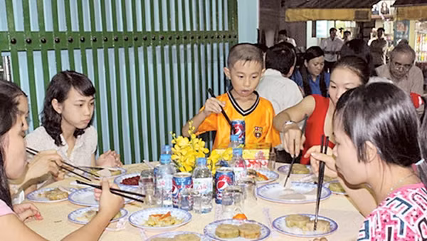 Các gia đình công nhân ăn Tết tại xóm trọ 143 Trần Thanh Mai, Q. Bình Tân, TP Hồ Chí Minh. Ảnh: TRUNG CHÁNH