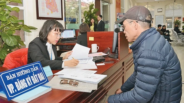 Cán bộ bộ phận "một cửa" UBND quận Nam Từ Liêm hướng dẫn người dân đến làm thủ tục hành chính.