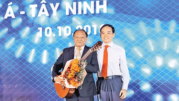 Bí thư Tỉnh ủy Trần Lưu Quang (bên phải) tặng đàn ghi-ta cho một nhà đầu tư.
