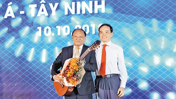 Bí thư Tỉnh ủy Trần Lưu Quang (bên phải) tặng đàn ghi-ta cho một nhà đầu tư.