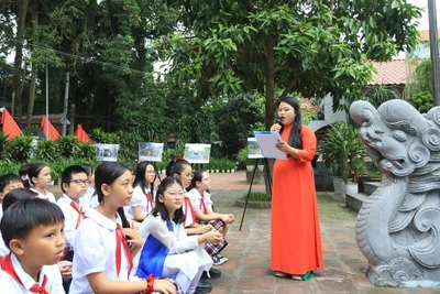 Các em học sinh Trường Tiểu học Xuân La (Hà Nội) học môn Lịch sử địa phương ngay tại di tích đình Quán La (phường Xuân La). (Ảnh: Giang Nam)