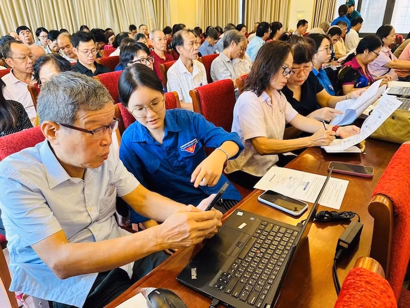 Đoàn viên thanh niên phường Văn Miếu-Quốc Tử Giám hỗ trợ các đảng viên thực hiện các thủ tục hành chính của Đảng trên Cổng dịch vụ công quốc gia. (Ảnh: BẢO LÂM). 