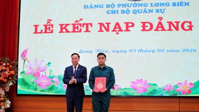 Bí thư Đảng ủy phường Long Biên trao quyết định kết nạp Đảng cho tân binh. (Ảnh: MINH PHÚC)