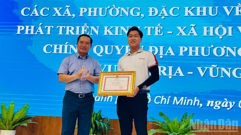 Chủ tịch Ủy ban nhân dân Thành phố Hồ Chí Minh Nguyễn Văn Được tặng bằng khen cho anh Cao Thành Đạt. (Ảnh: Vương Lê) 