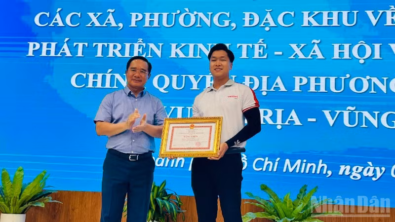 Chủ tịch Ủy ban nhân dân Thành phố Hồ Chí Minh Nguyễn Văn Được tặng bằng khen cho anh Cao Thành Đạt. (Ảnh: Vương Lê) 