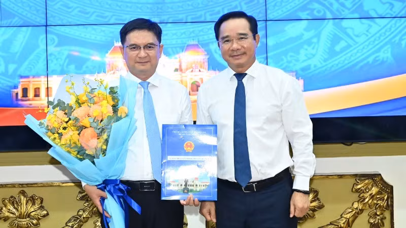 Chủ tịch Ủy ban nhân dân Thành phố Hồ Chí Minh Nguyễn Văn Được trao quyết định, tặng hoa chúc mừng đồng chí Nguyễn Mạnh Cường. (Ảnh: VIỆT DŨNG)